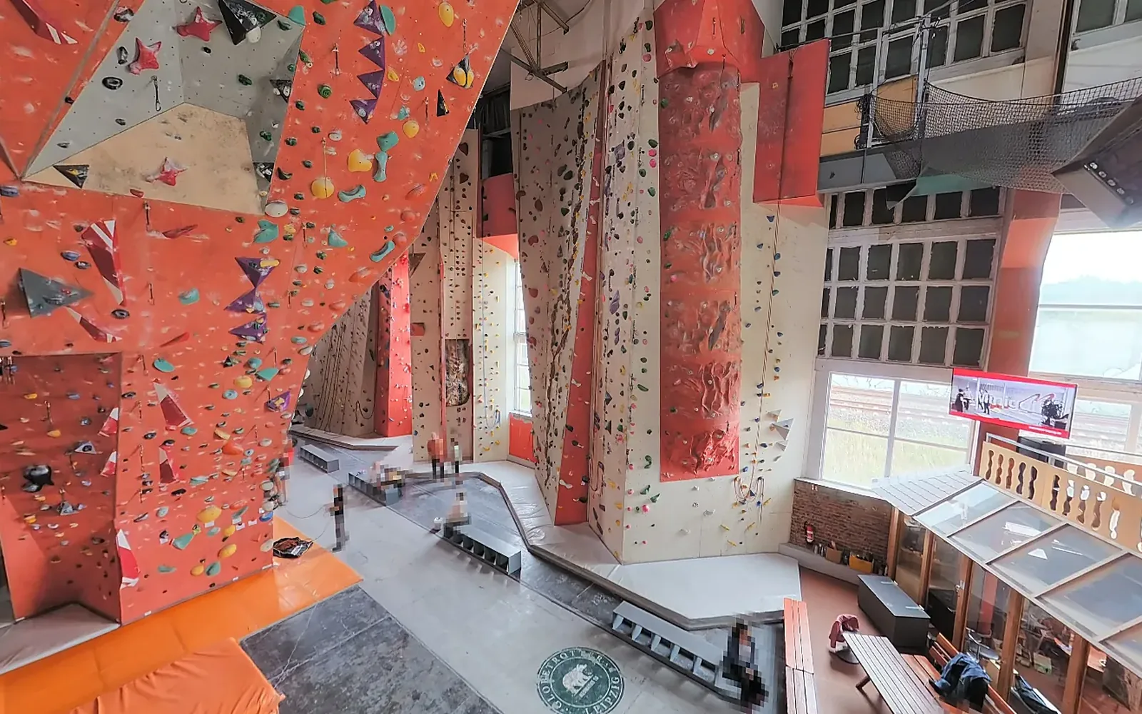 Ausschnitt aus einem 360°-Rundgang: Haupthalle einer Kletterhalle mit Wänden, Galerie und Fensterfront, Personen unkenntlich gemacht